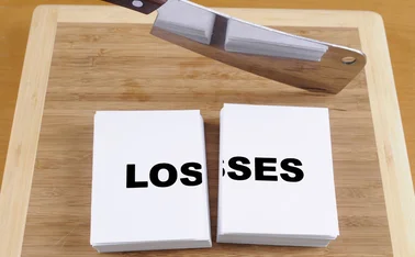 A meat cleaver cutting through the word losses