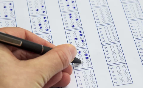 Filling exam questionnaire,hand with pen marking right answers 