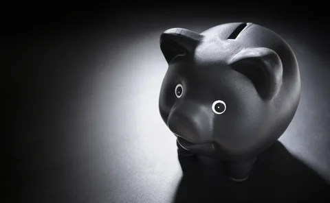 Black piggy bank on blackboard background