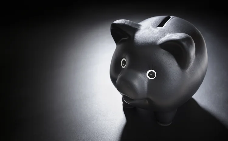 Black piggy bank on blackboard background